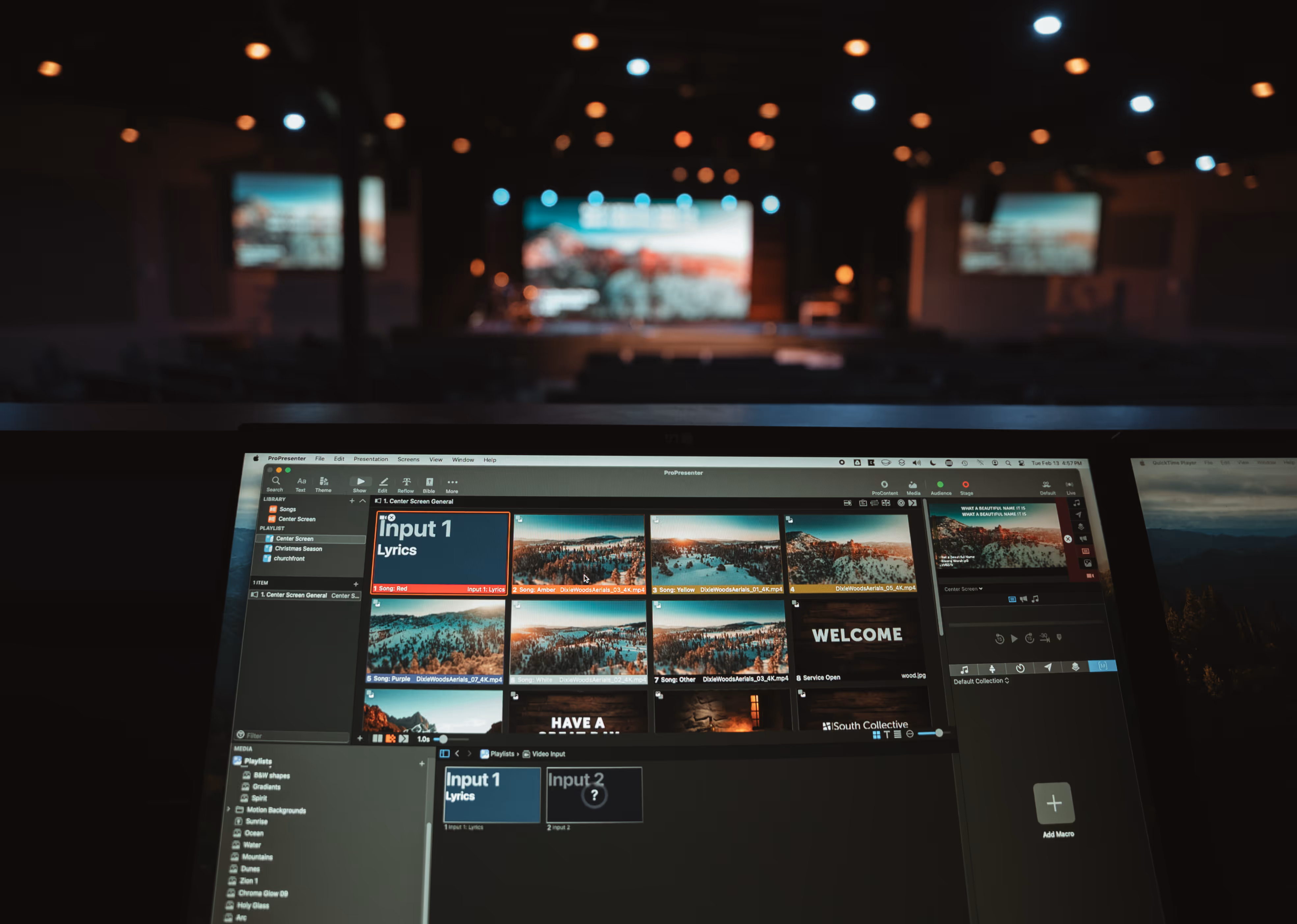 Church production booth with lighting console and multi-screen display.