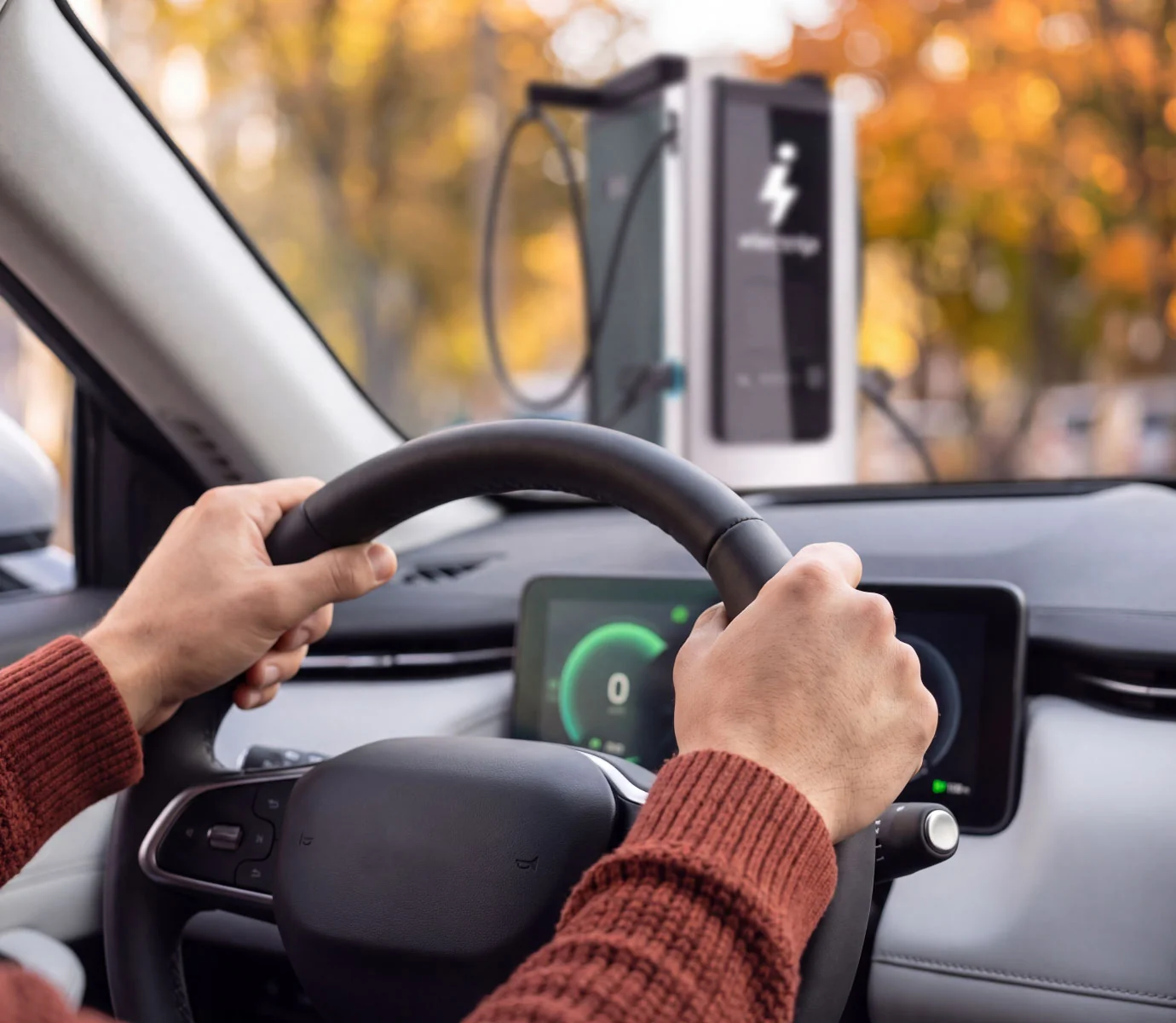 Automobilista alla guida che riparte dopo la ricarica alla colonnina Electrip