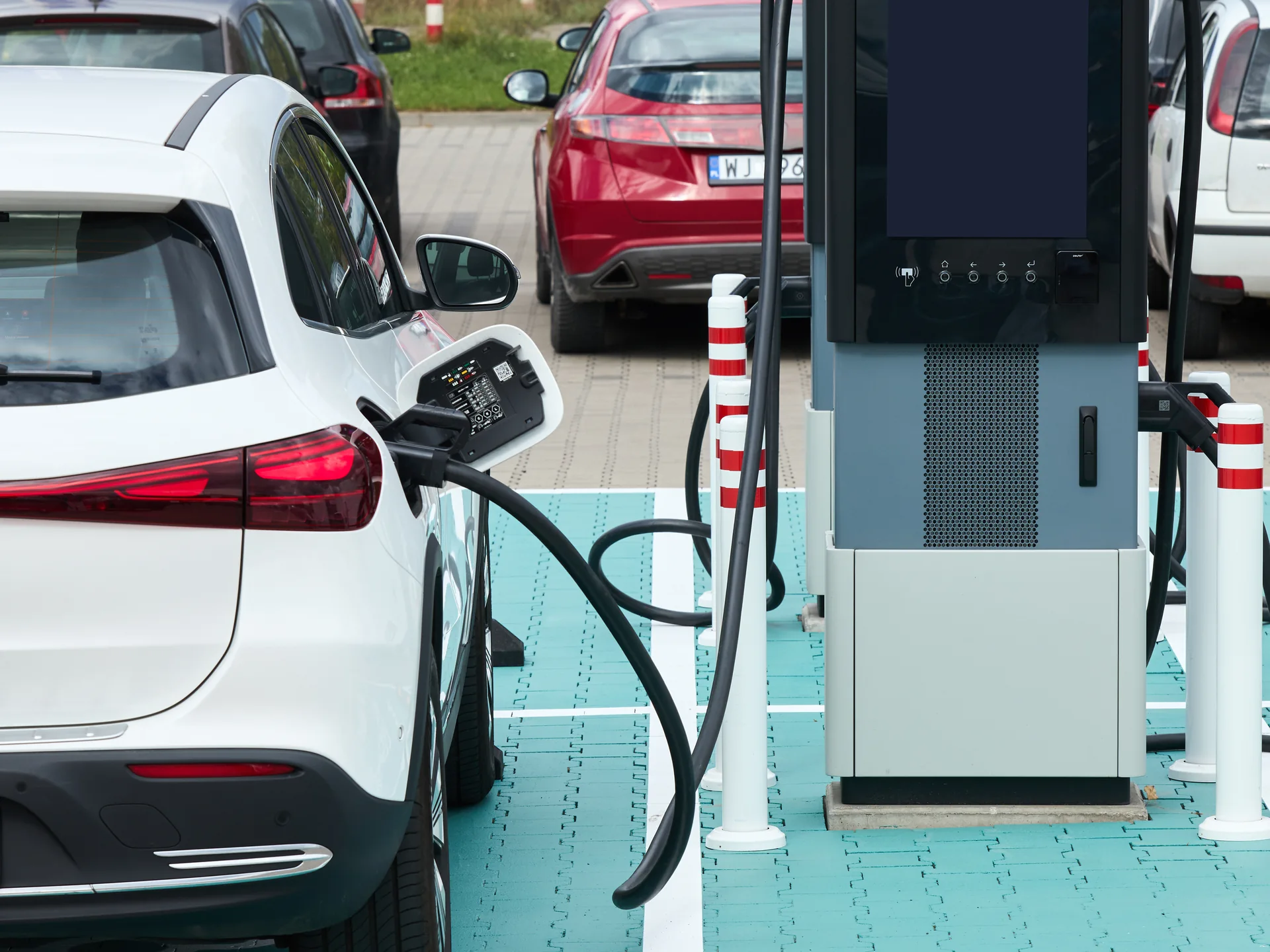 Samochód elektryczny ładowany przy ładowarce Electrip na parkingu parku handlowego