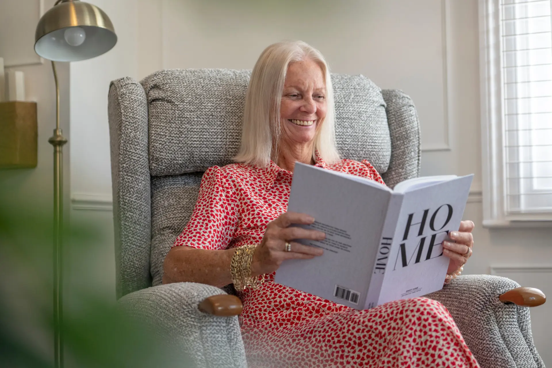 woman reading book on riser recliner chair