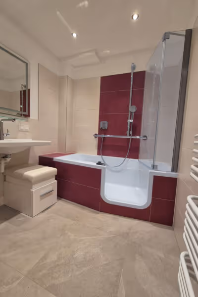 Modernes Bad mit roter und weißer Gestaltung, kombinierter Wanne und Dusche.