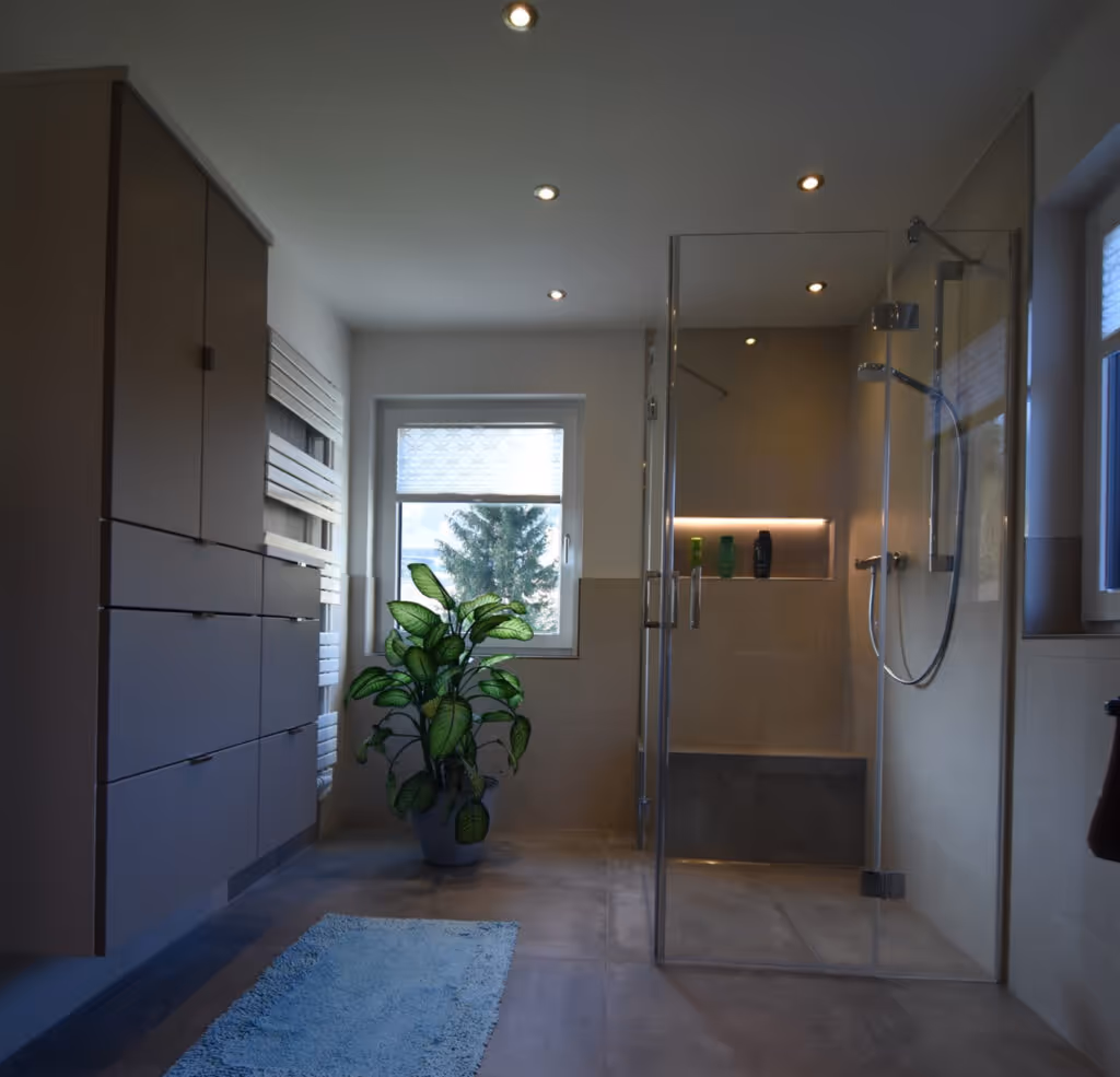 Modernes, renoviertes Bad mit bodengleicher Dusche, Pflanzen und heller Beleuchtung.