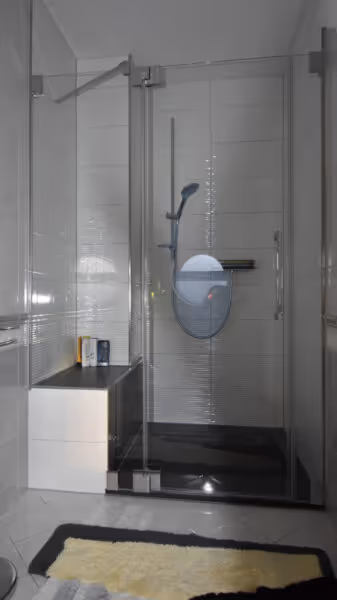 Modernes Bad mit Glasdusche und hellen Fliesen