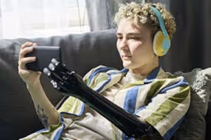 Eine Person mit einer Armprothese nutzt ein Smartphone mit einer barrierefreien Website.