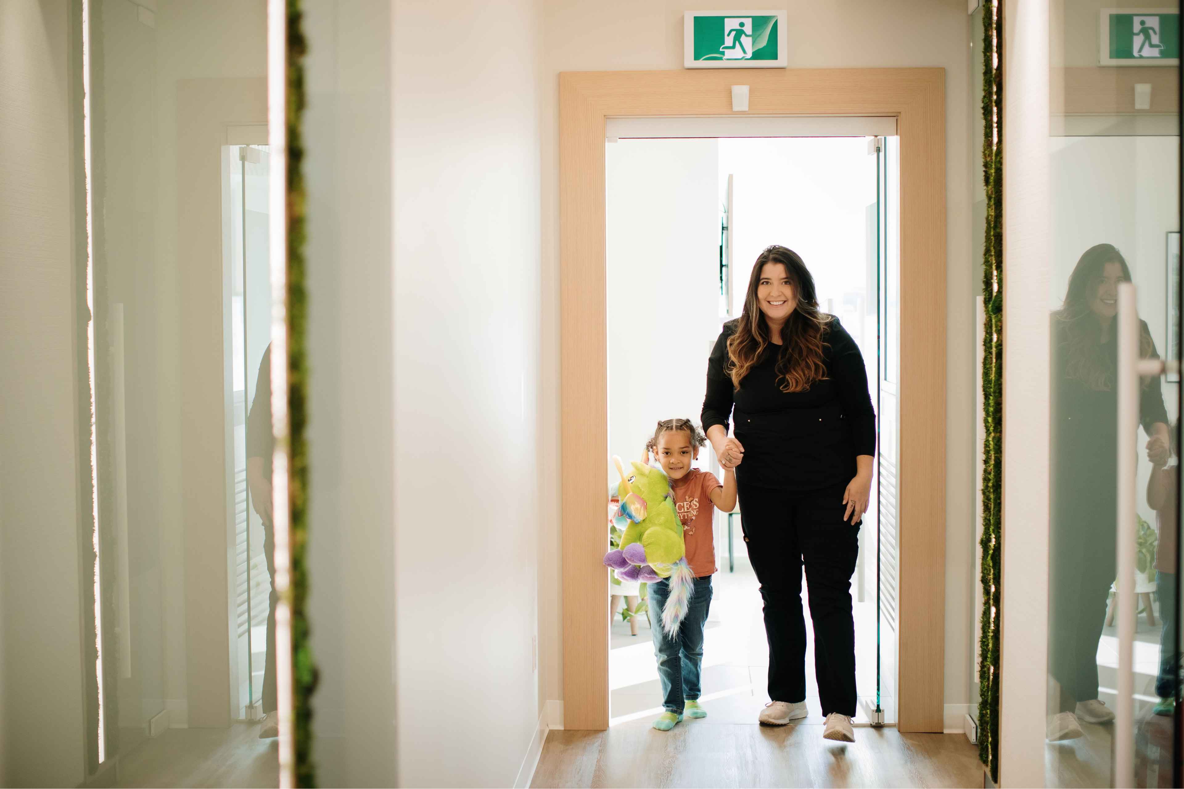 Office Manager walking a child to the waiting area in Newbury Dental