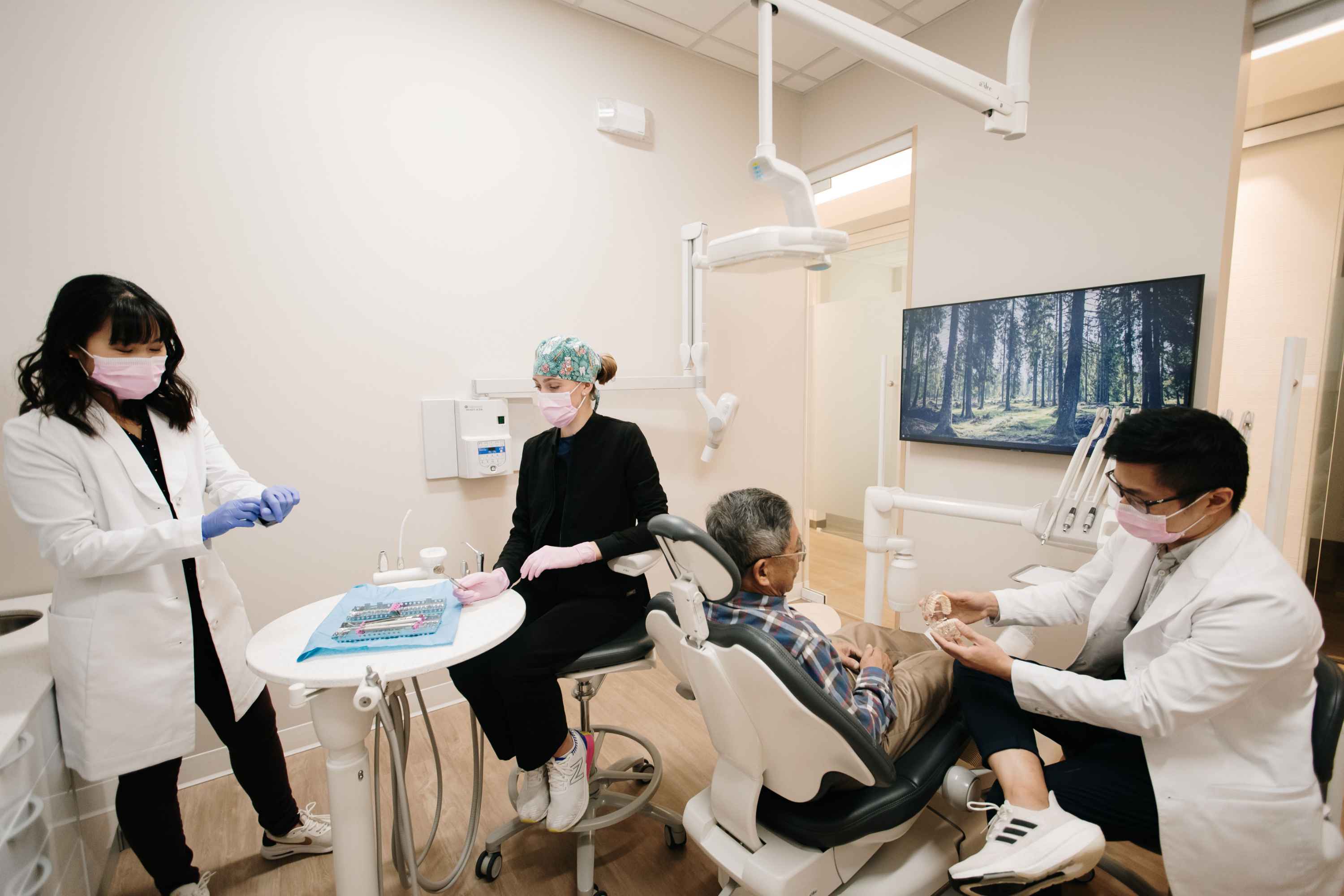 Dr. Lee, Dr. Ngai, and hygienist prepping a patient for procedure