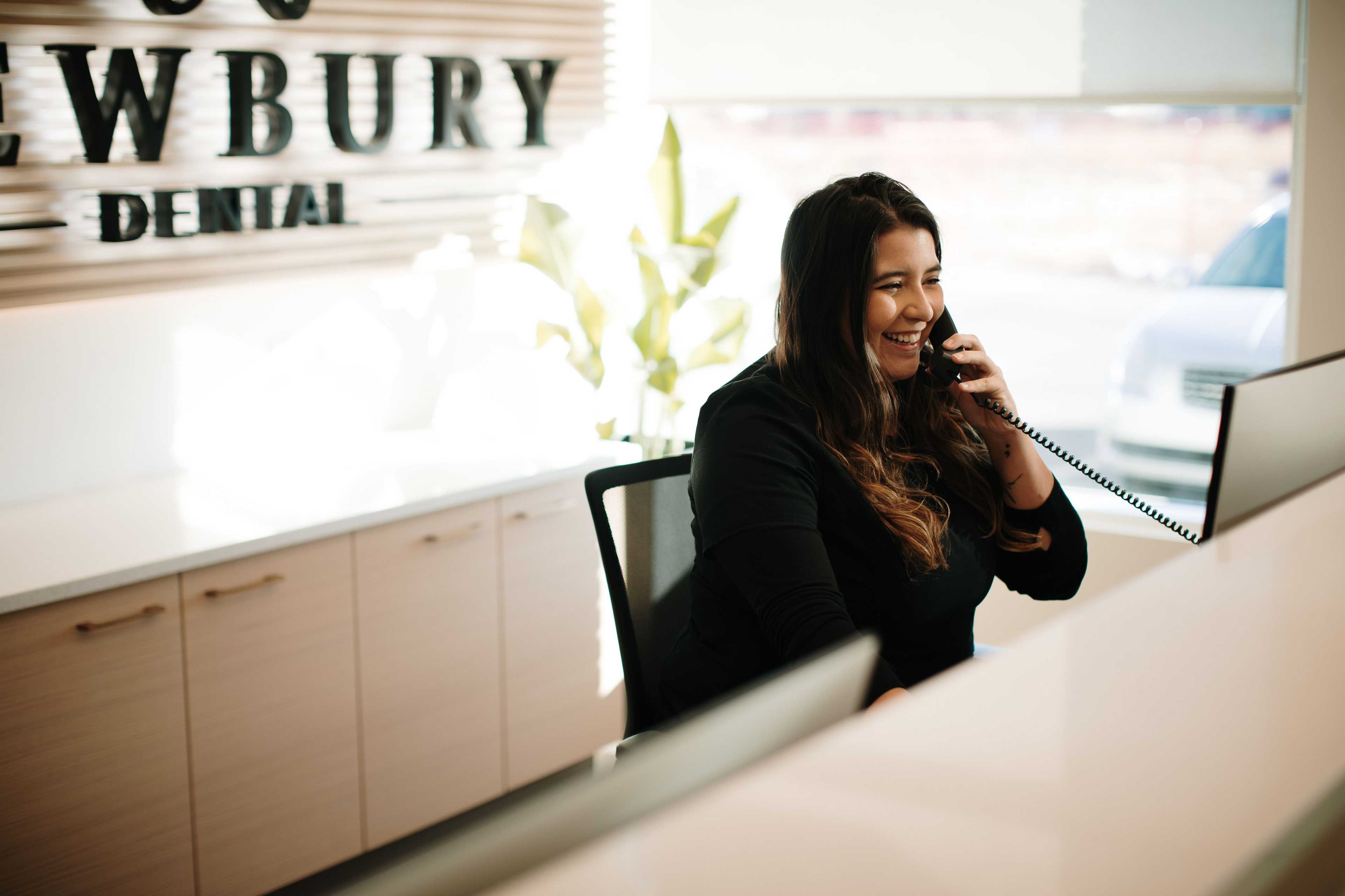 Office manager answering phone to set up a dental appointment