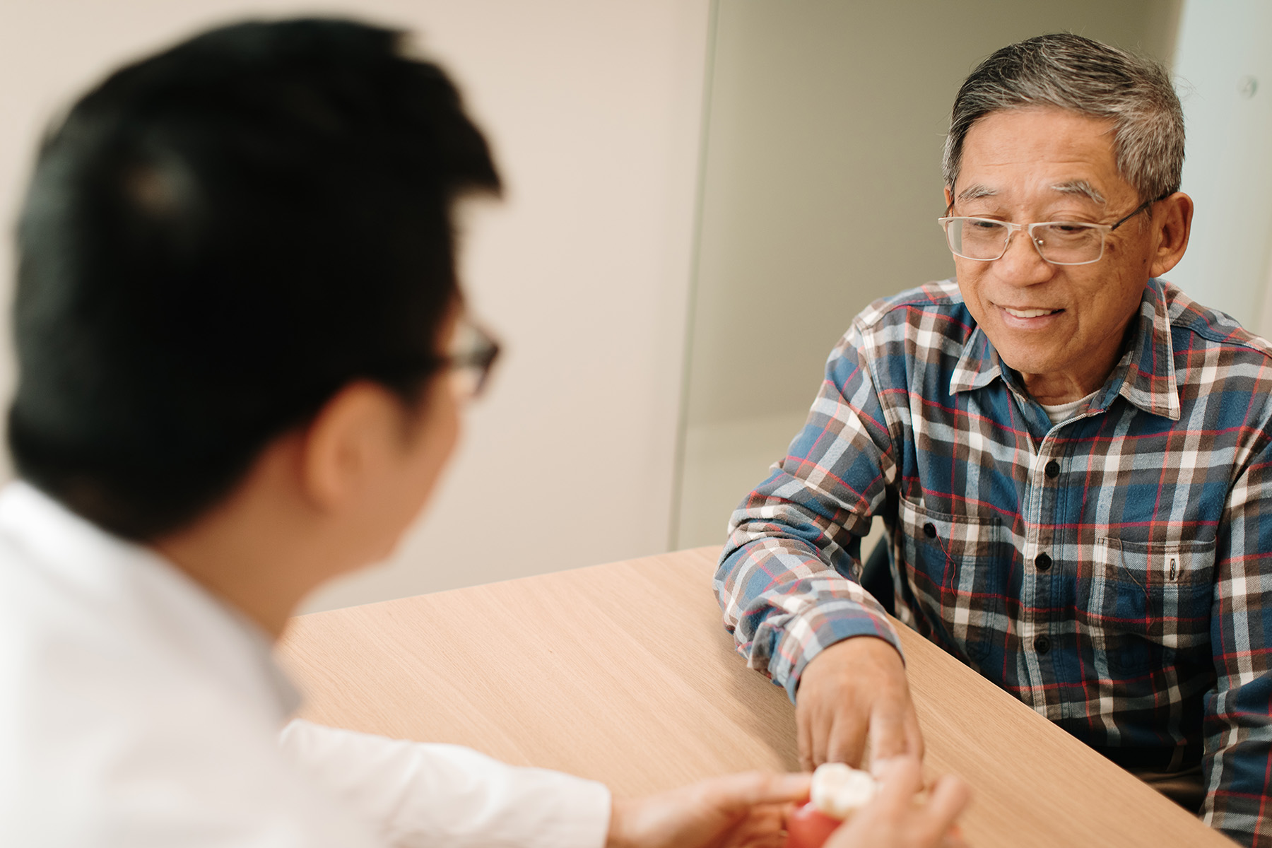Dr. Ngai discussing insurance options with a couple