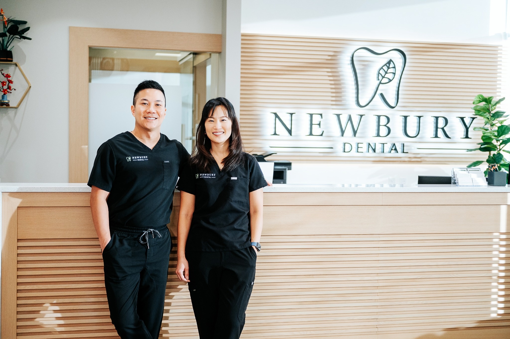 Dr. Lee locking arms with Dr. Ngai in the waiting room of Newbury Dental
