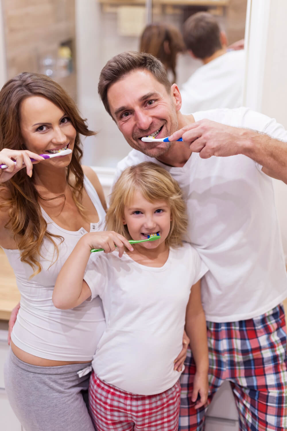 A happy family brushing their teeth together thanks to Newbury Dental Clinic Edmonton