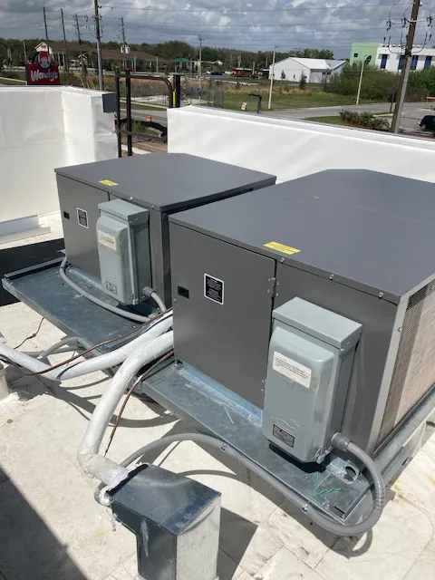 Gray electrical equipment and utility boxes on a concrete rooftop