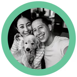 Smiling couple holding a small fluffy dog inside a green circular frame.