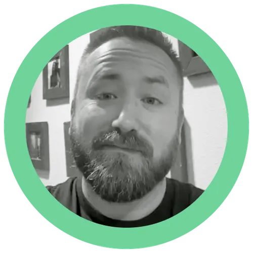 Black and white close-up portrait of a bearded man with short hair inside a green circular frame.