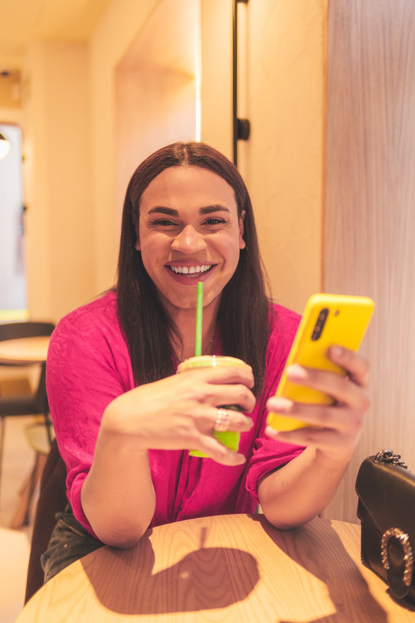 Trans woman sits at table with a drink, discussing can transgender women produce sperm