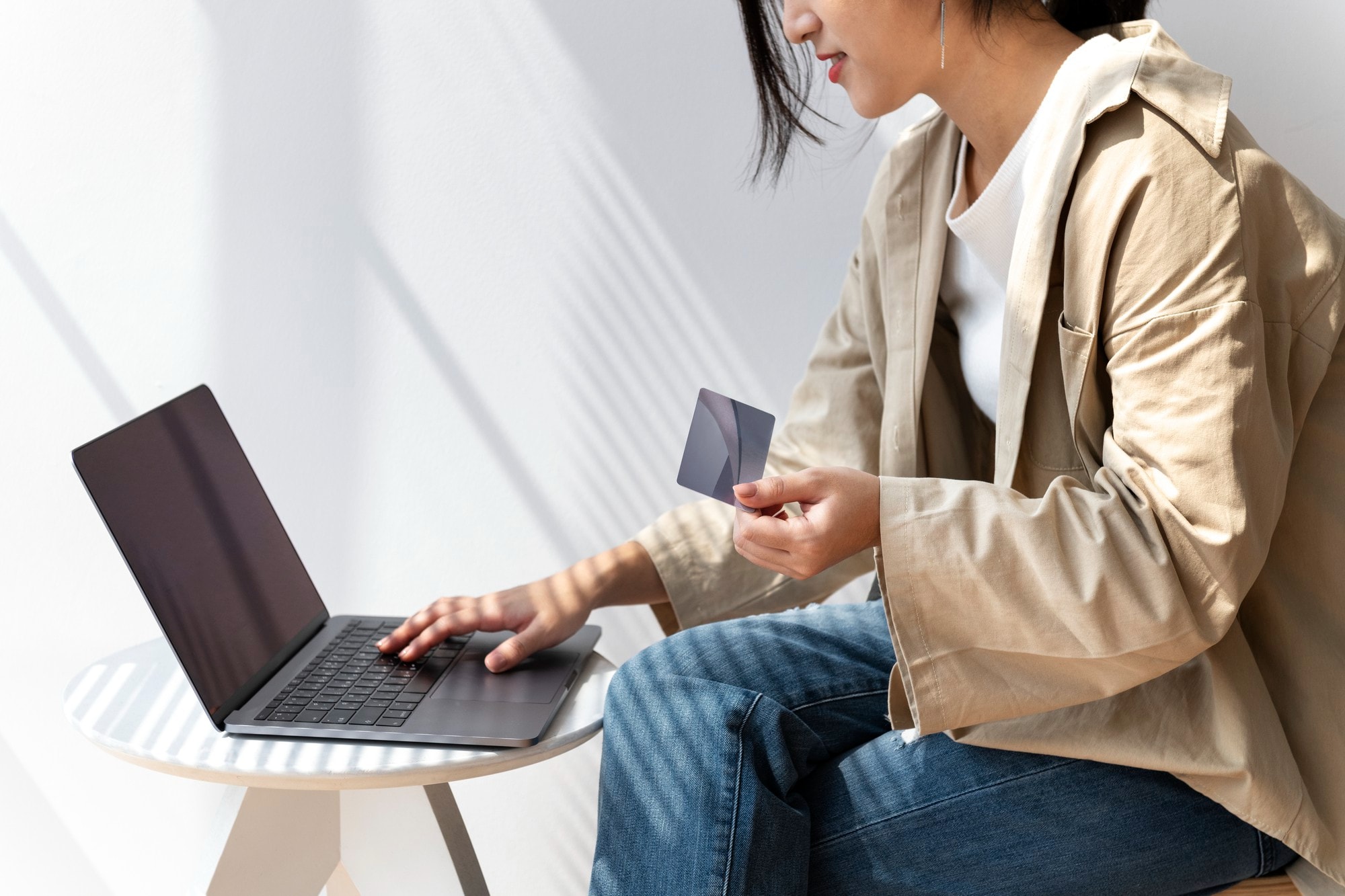Woman using a laptop and holding a credit card