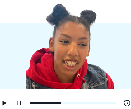 A young smiling girl wearing a hoodie and a denim jacket