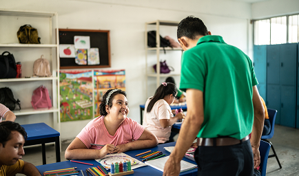 Teacher helping disabled students in the classroom at school