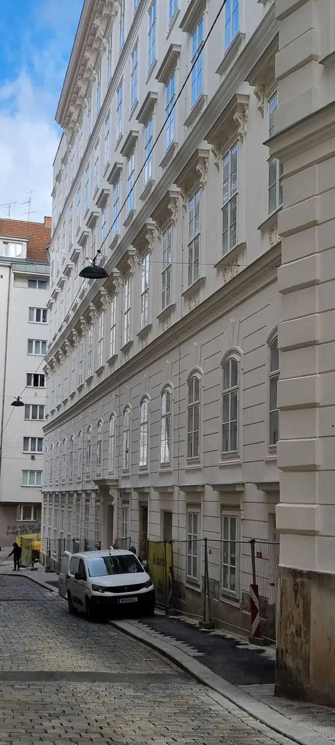 Rytmus oblúkových drevených kastlových okien na klasickej viedenskej fasáde.