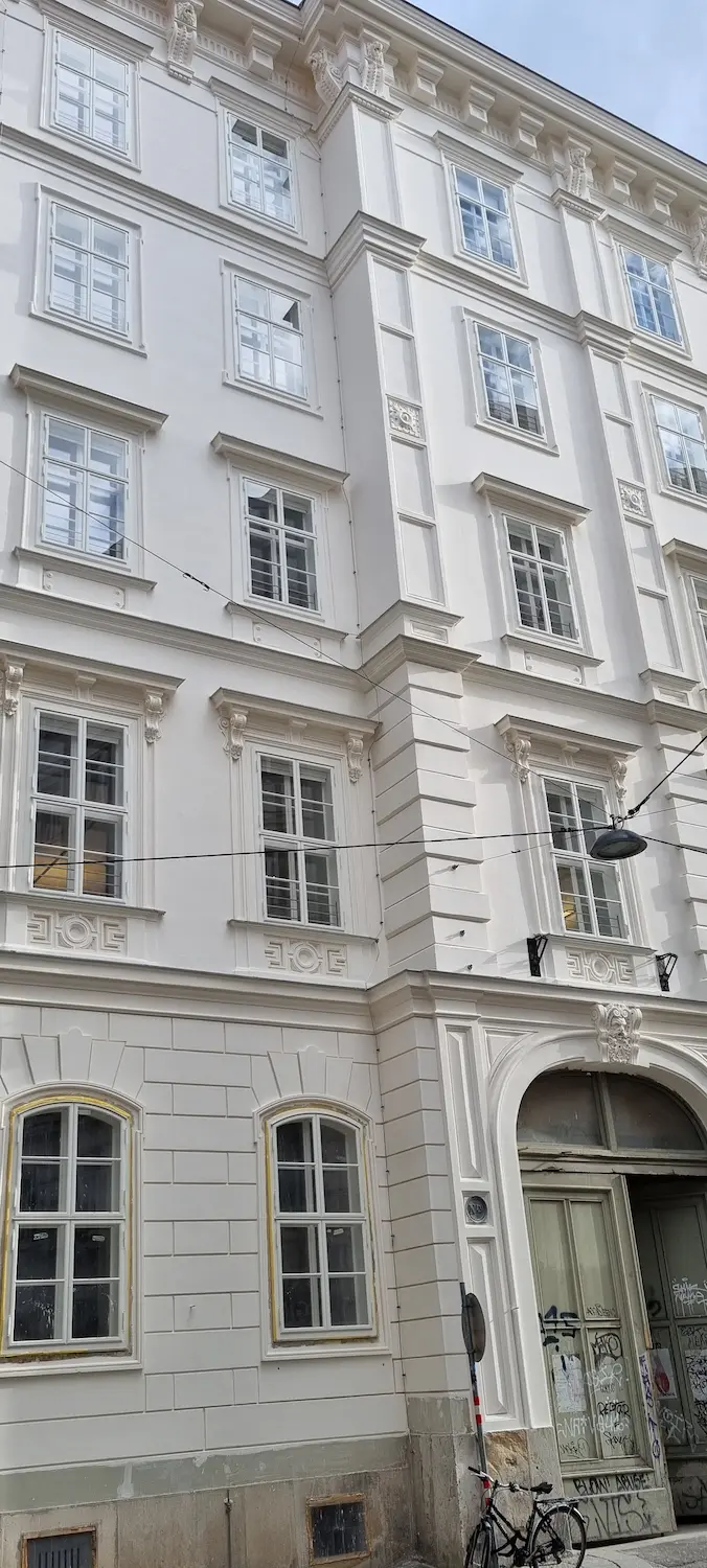 Symetrické línie drevených okien na budove vo Viedni.