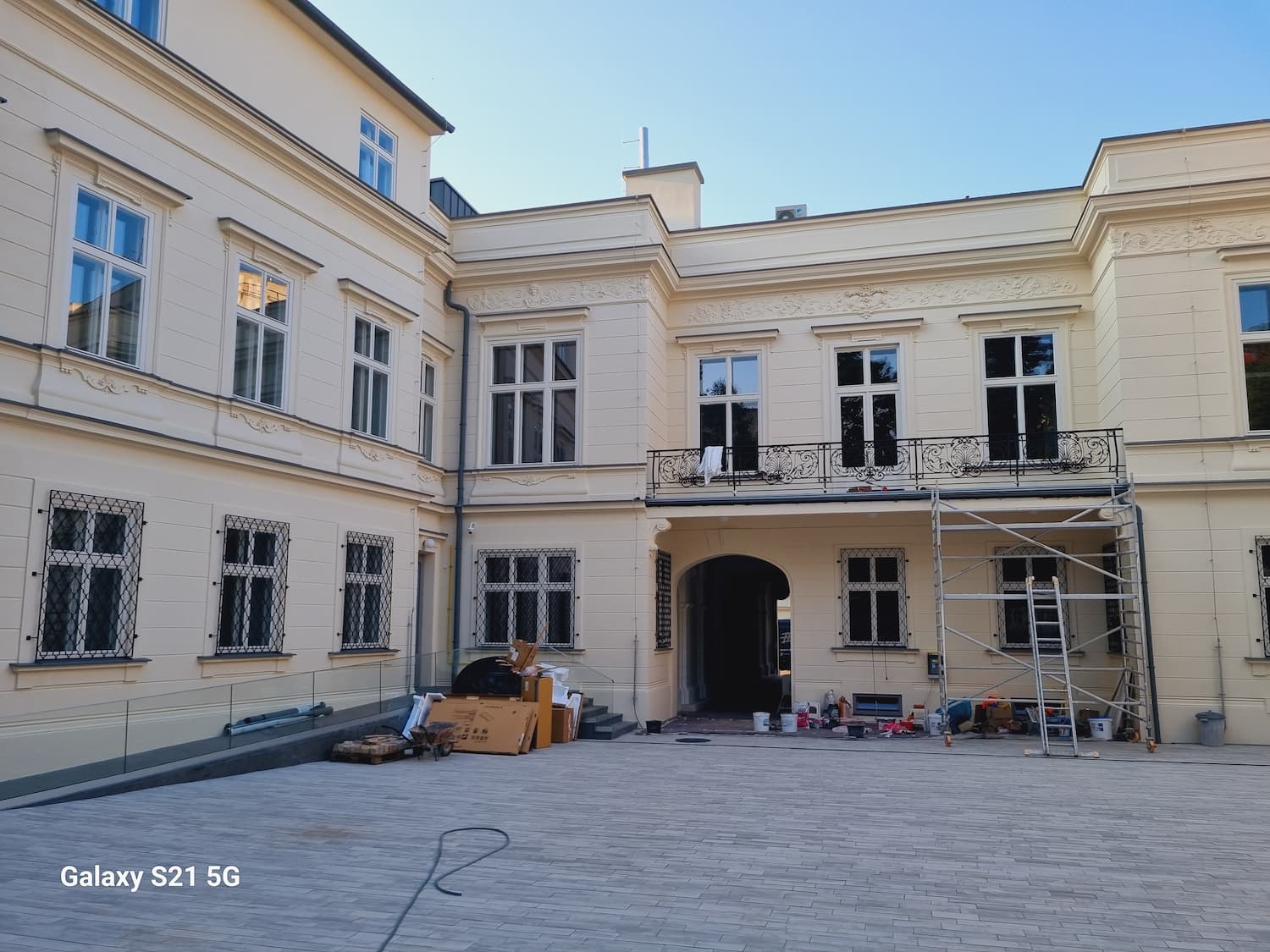 Nádvorie budovy počas rekonštrukcie, zachytávajúce vnútorné krídla paláca s lešením a stavebným materiálom.