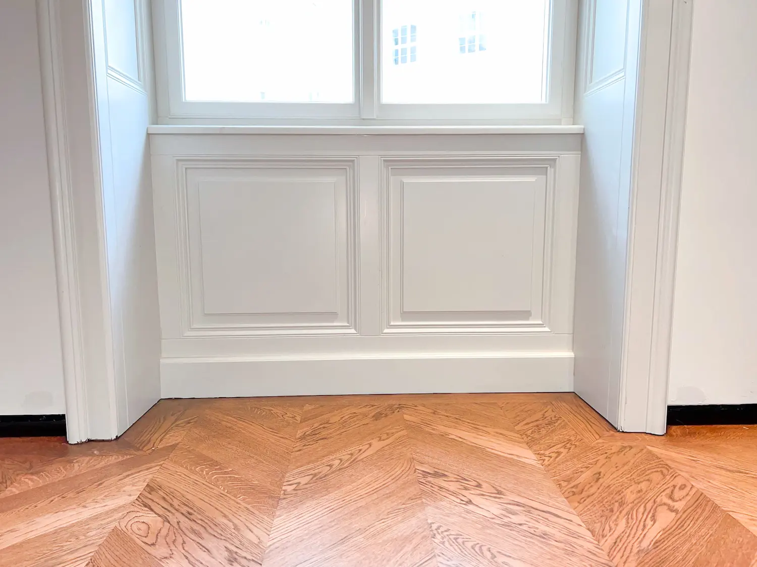 Detail spodného dreveného obkladu parapetu v klasickom štýle.