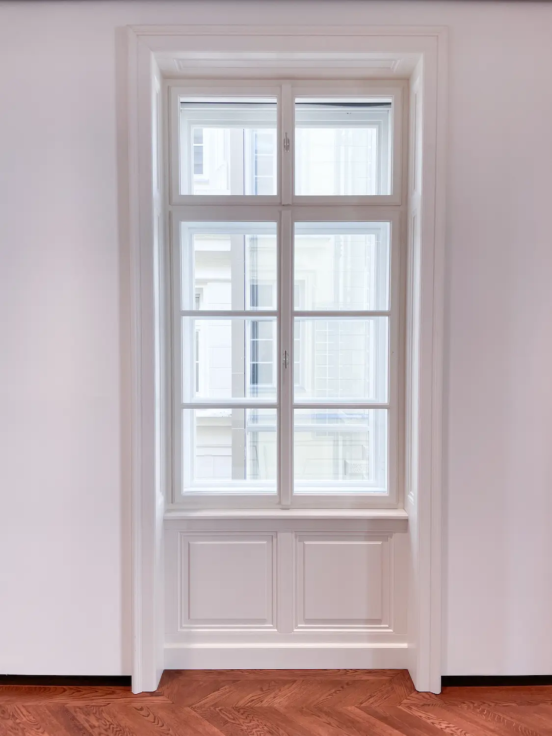 Profil bieleho dreveného kastlového okna zapustený do hlbokého ostenia.