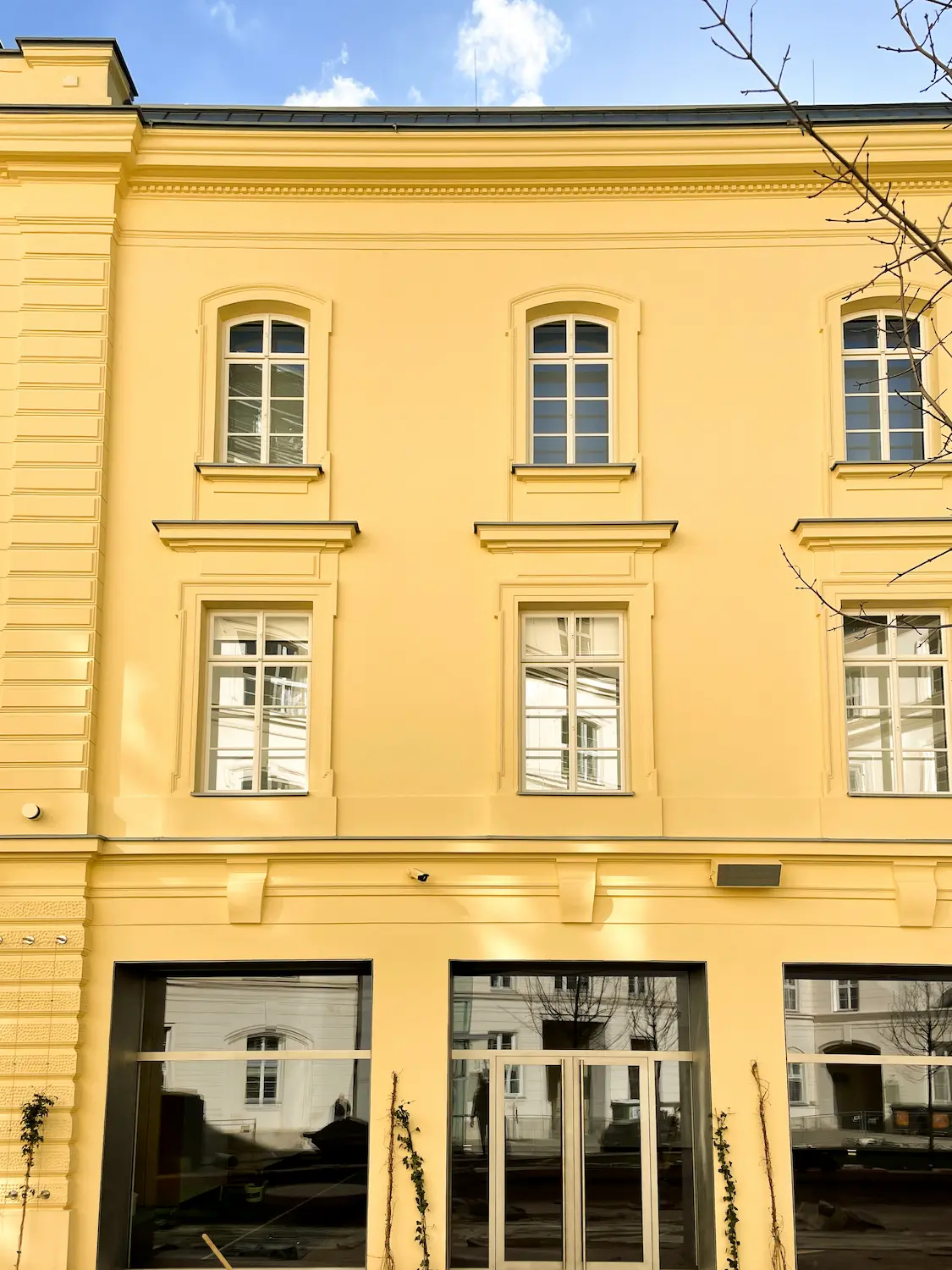 Detail masívneho dekoratívneho ostenia okolo dreveného okna.