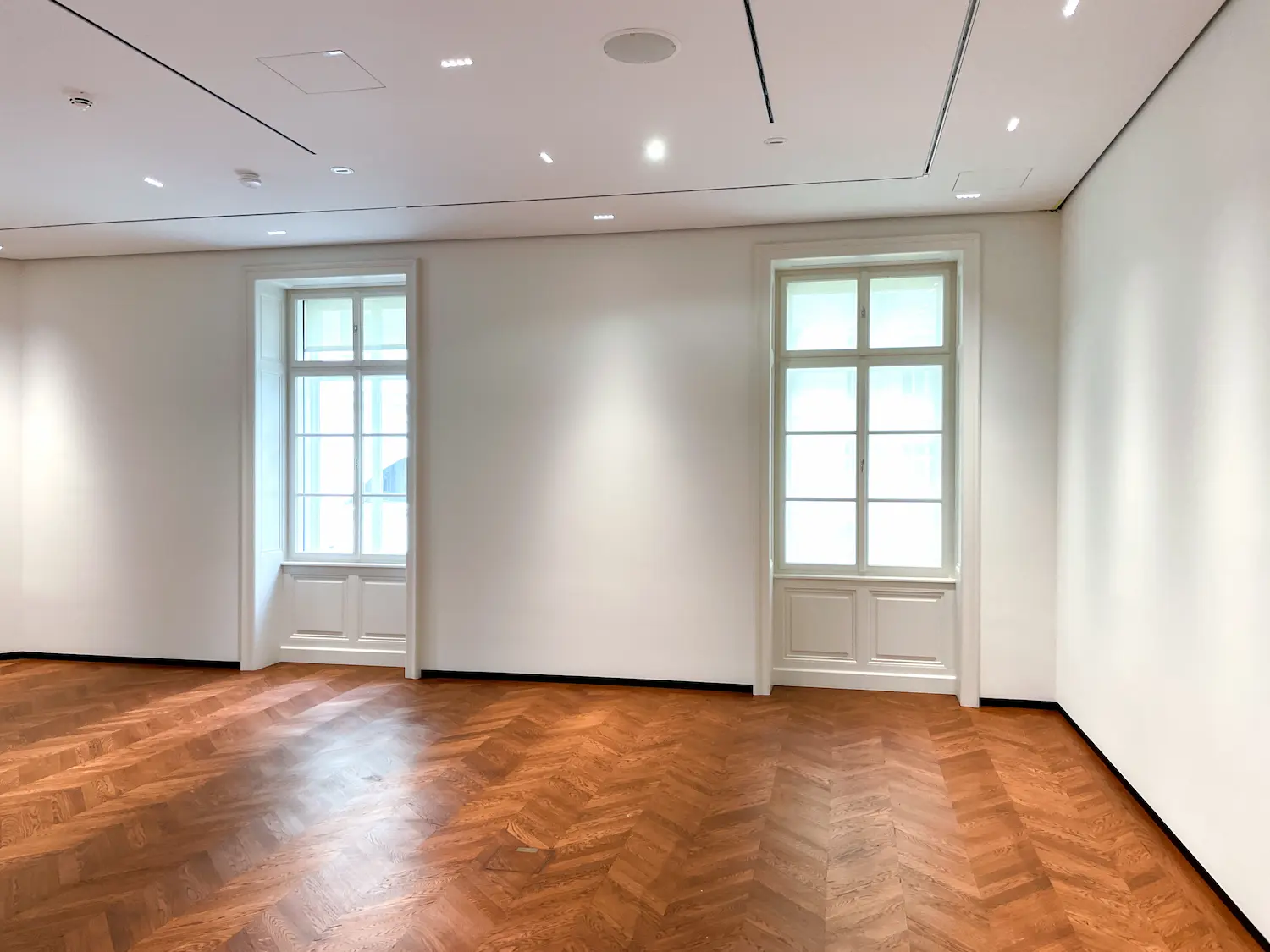 Ladenie drevených okien s tradičnou parketovou podlahou.