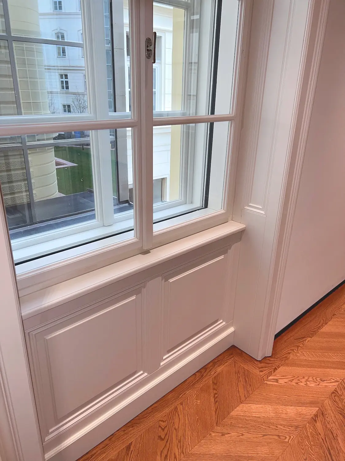 Elegantné ostenie pod dreveným oknom v byte Kolingasse.