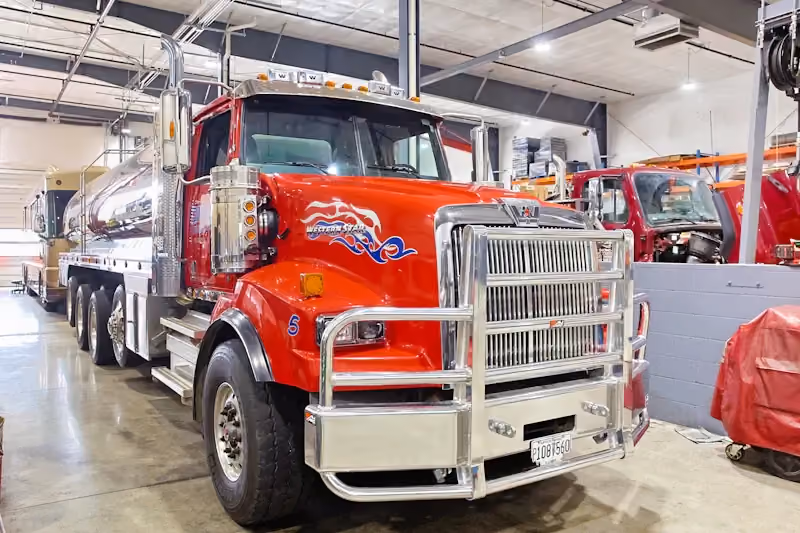 DOT inspection with Western Star tanker truck positioned in shop bay for commercial vehicle safety and compliance check.