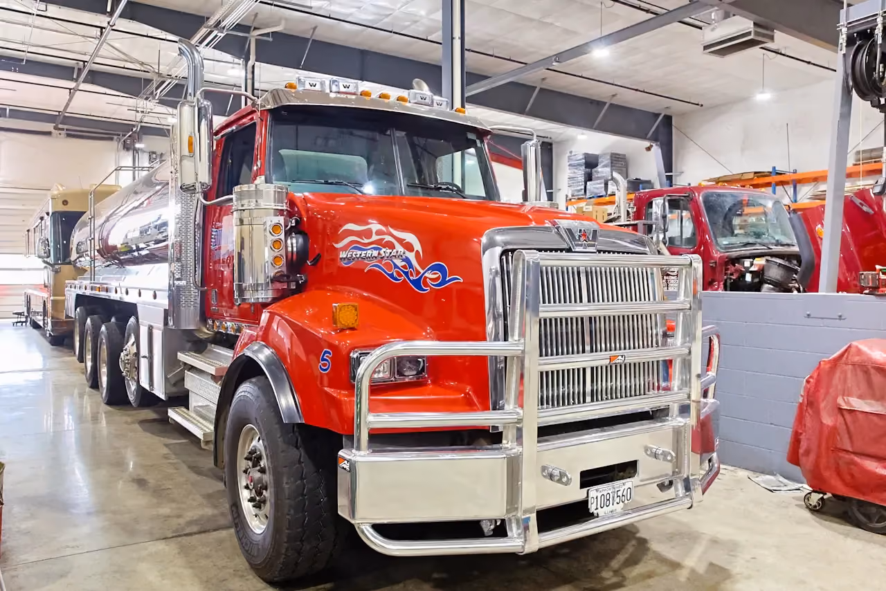 DOT inspection with Western Star tanker truck positioned in shop bay for commercial vehicle safety and compliance check.