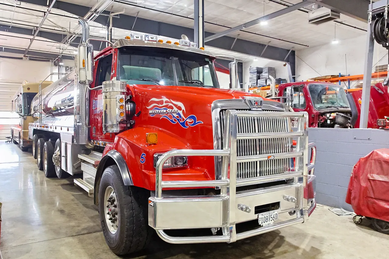 DOT inspection with Western Star tanker truck positioned in shop bay for commercial vehicle safety and compliance check.