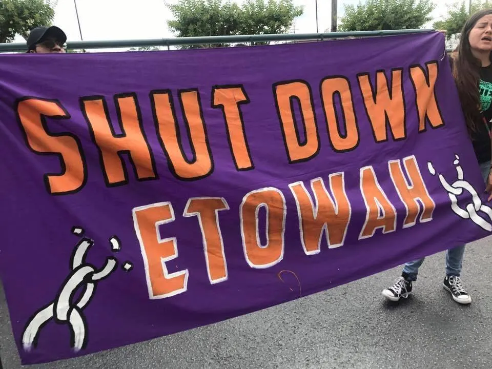 Close up of large painted banner at protest reading Shut Down Etowah.