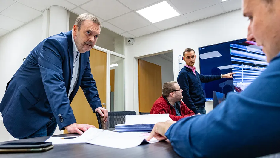 Geschäftsmeeting – moderne Bürosituation mit Führungskräften und Mitarbeitern am Tisch