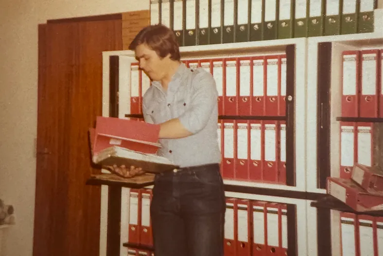 Historisches Foto – Mitarbeiter bei der Arbeit im Büro mit Aktenordnern