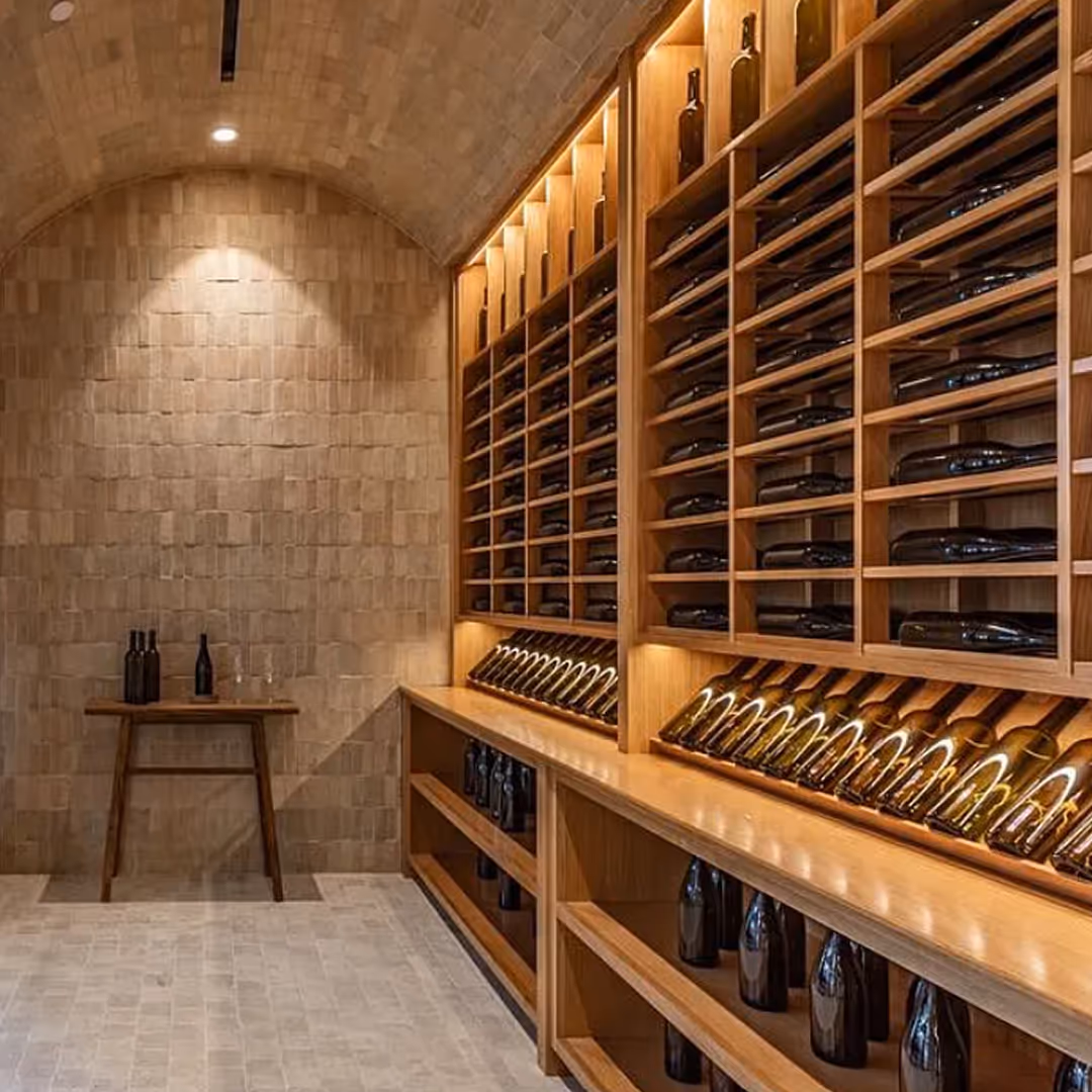 Custom wine cellar with integrated LED lighting by Totally Wired Electric, highlighting premium bottle displays in luxury home.