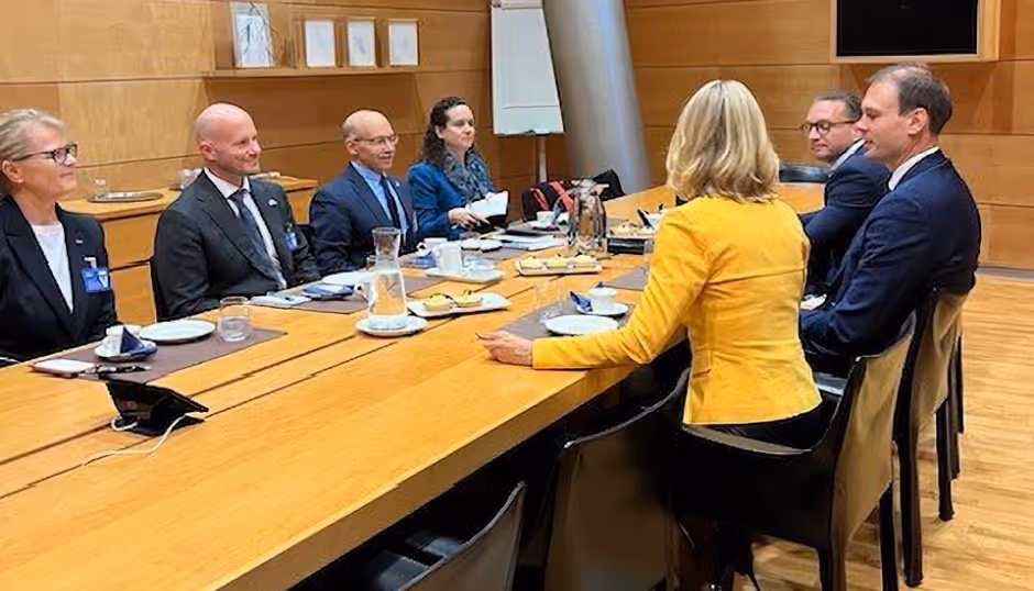 Dr. Totah at a conference table having a discussion with Finnish and US officials at diplomatic meeting