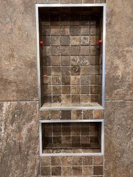 A niche with large format tile on the outside wrapped with a matching mosaic inside.