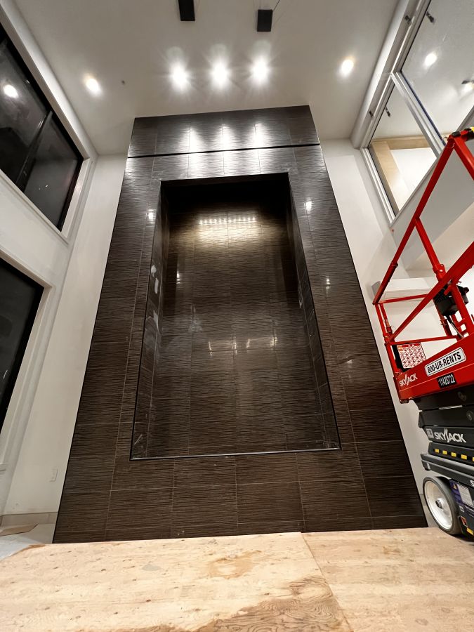 a water wall with dark tile installed 20 feet high