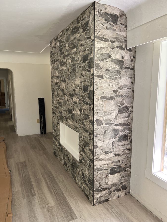 a textured tile made to mimic a stone installed on an electric fireplace insert.