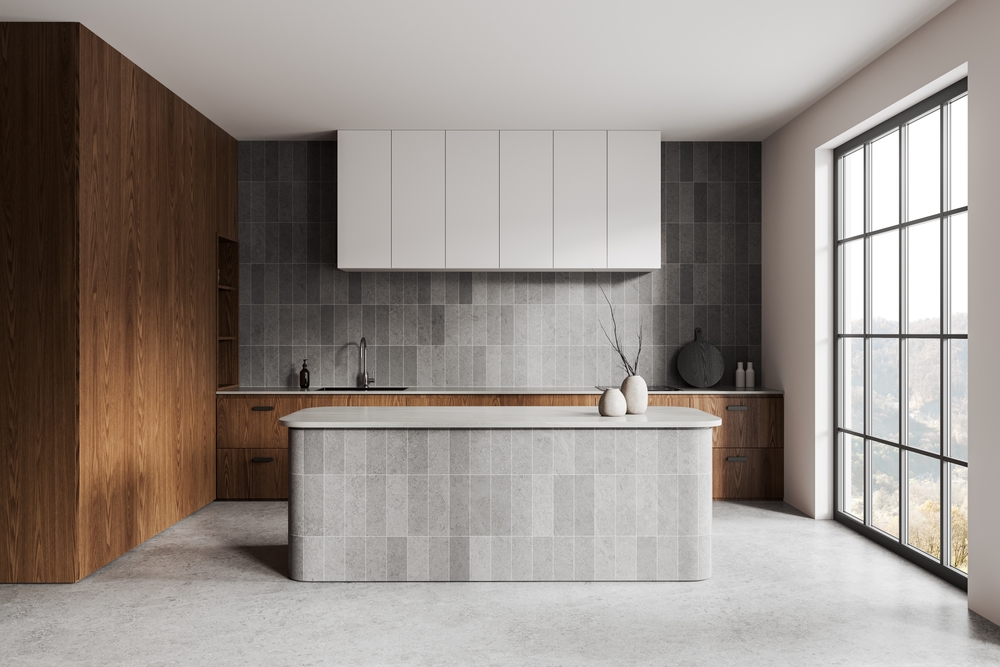 A kitchen with grey subway tiles installed vertically on the backsplash and island. Matching large format grey tiles are on the kitchen floor