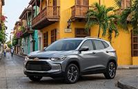Gray Chevrolet SUV parked on a cobblestone street with colorful buildings and palm trees in the background.