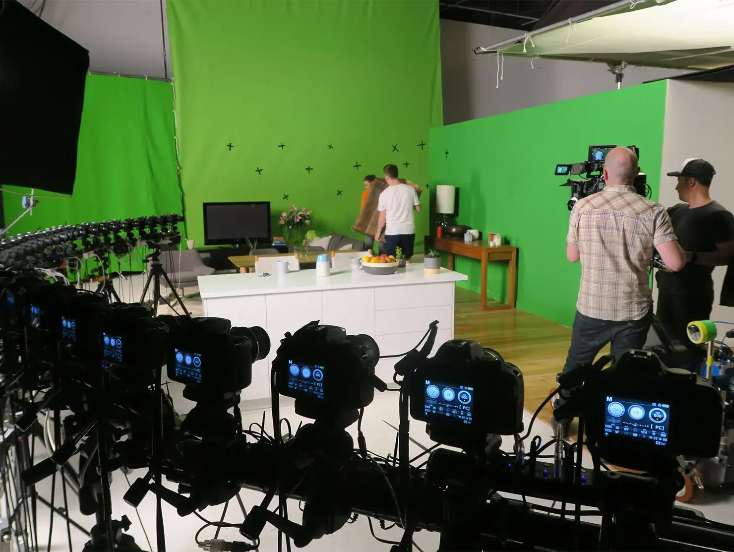 Behind-the-scenes setup with multiple cameras and green screen during production of the Terri Scheer Landlord Insurance TV campaign.