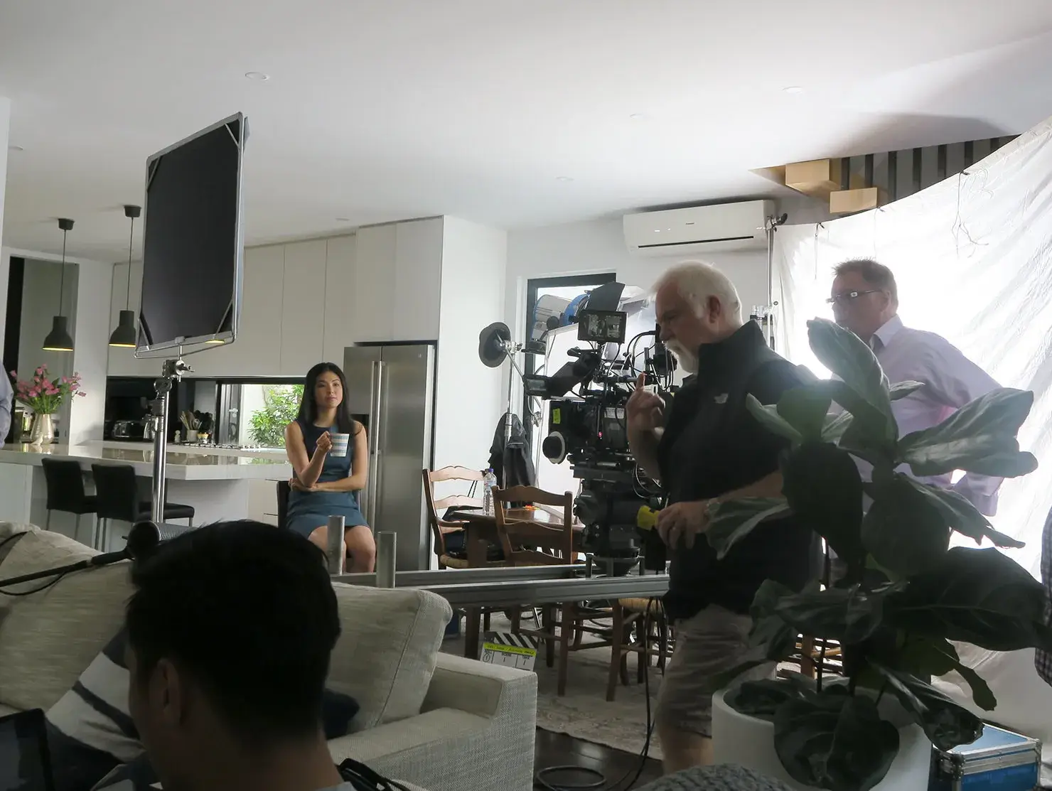 Film crew shooting in a modern kitchen with an first-time investor actor, behind-the-scenes of the Terri Scheer Landlord Insurance TV commercials.