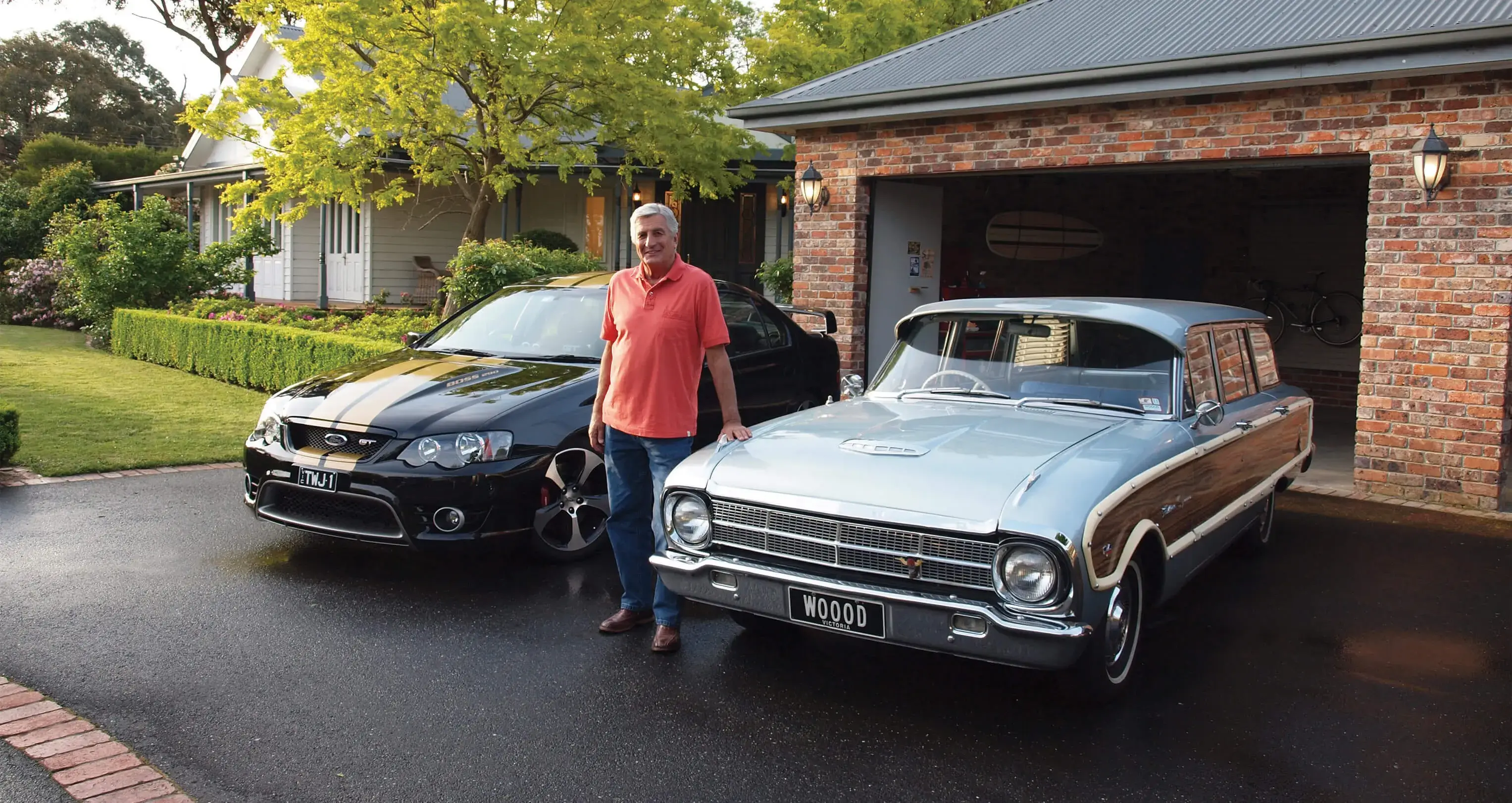 Classic car owner standing proudly in driveway with his black Ford GT and silver Ford Falcon wagon, featured in Shannons Insurance for Motoring Enthusiasts TV commercial.