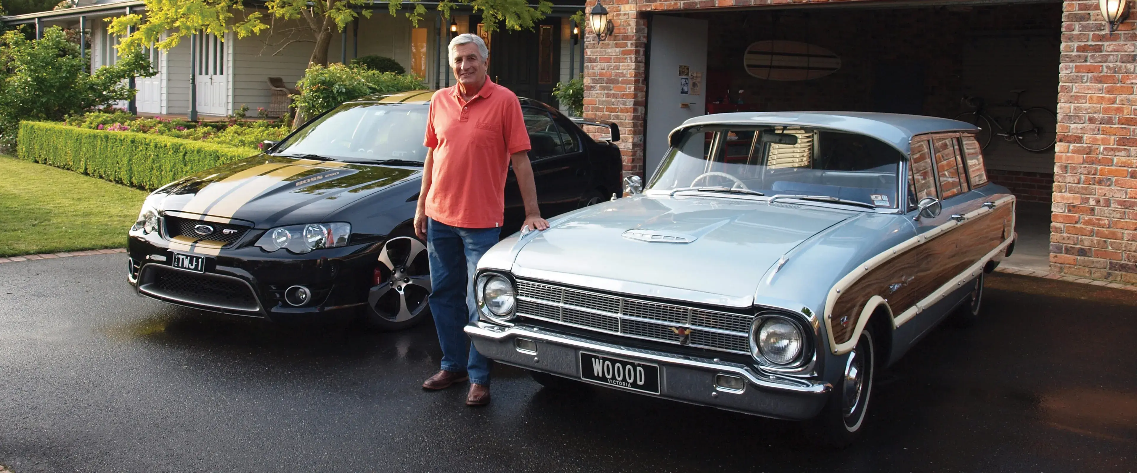 Classic car owner standing proudly in driveway with his black Ford GT and silver Ford Falcon wagon, featured in Shannons Insurance for Motoring Enthusiasts TV commercial.