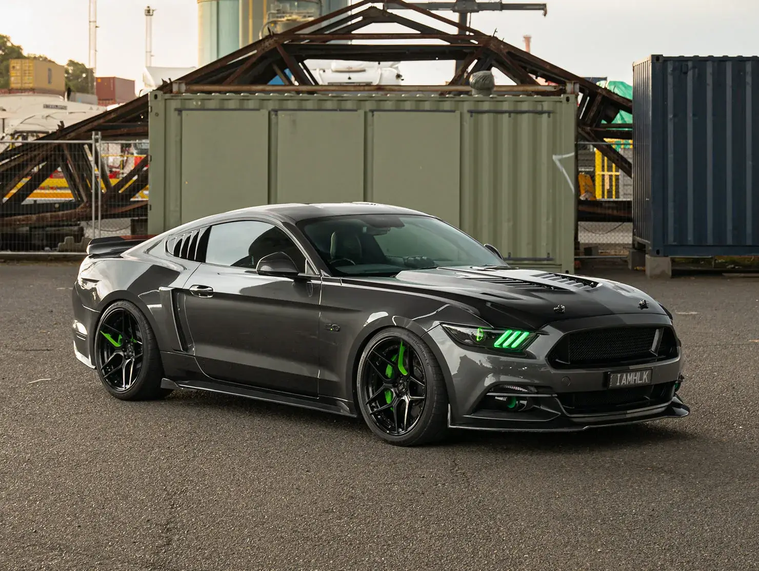 Grey modified Ford Mustang coupe with green accents and black wheels, photographed in industrial setting - Shannons Vehicle Photography