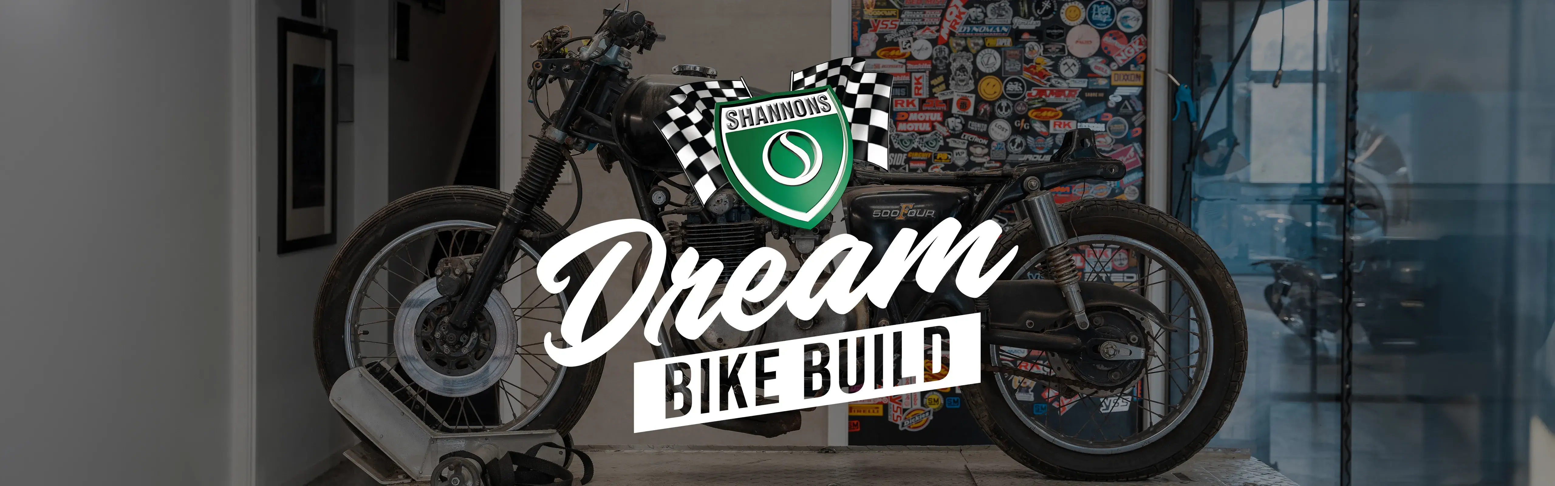 A vintage motorcycle sits on a workshop bench at the start of its restoration, overlaid with the Shannons Dream Bike Build logo, marking the launch of the Shannons Dream Bike Build YouTube Series.