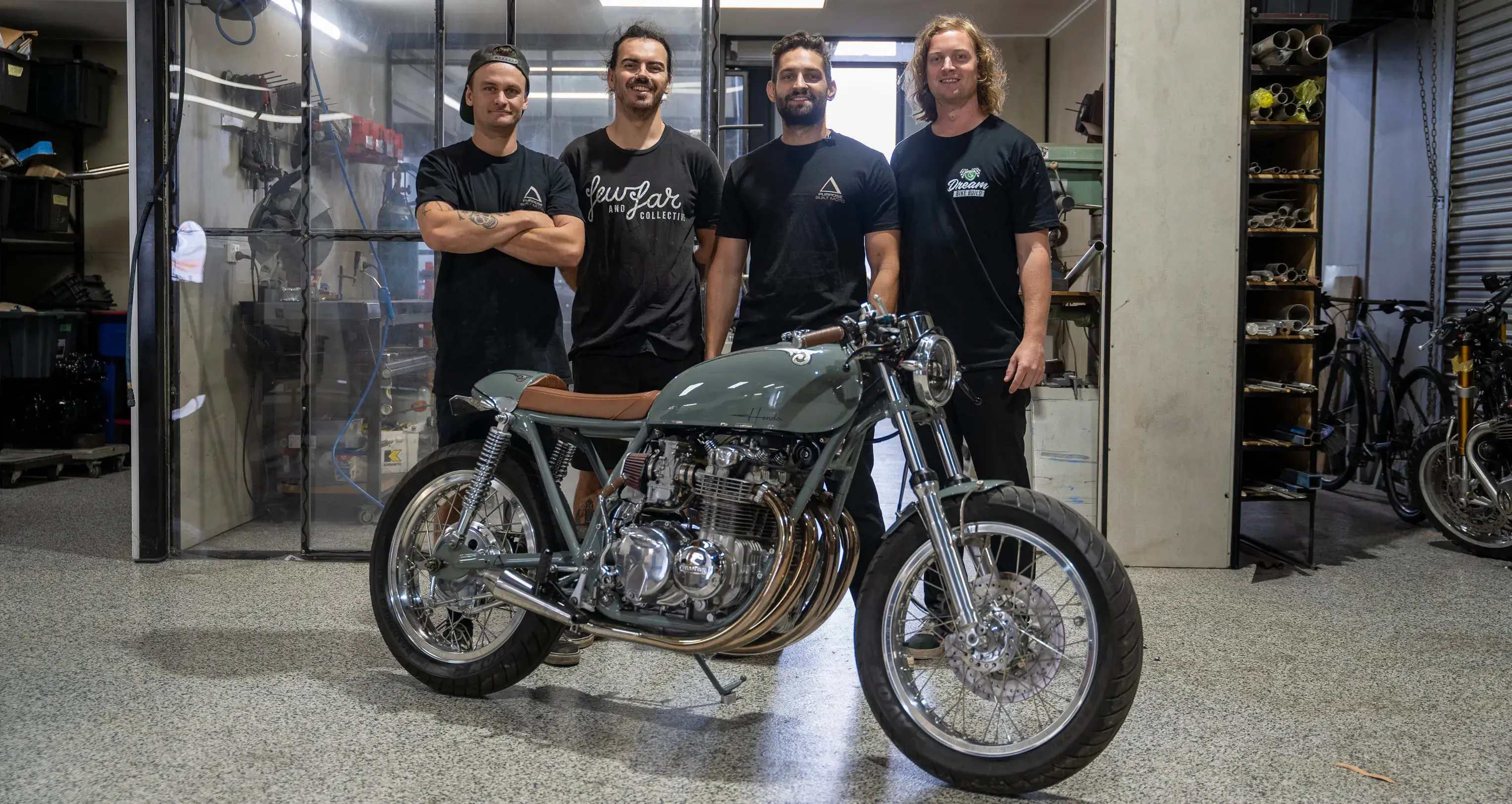 The Purpose Built Moto team stand proudly with the completed custom café racer, the finished motorcycle from the Shannons Dream Bike Build YouTube Series.