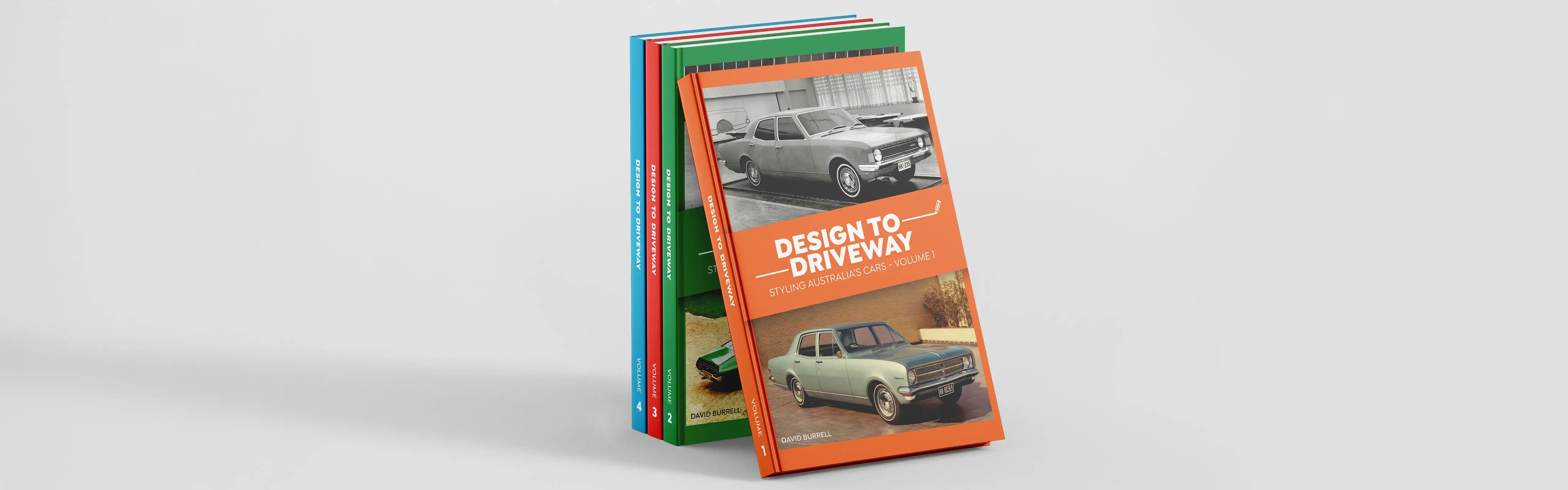 A stack of the Design to Driveway book series featuring colourful covers with Australian classic cars, showcasing volumes 1–4 in the collection.